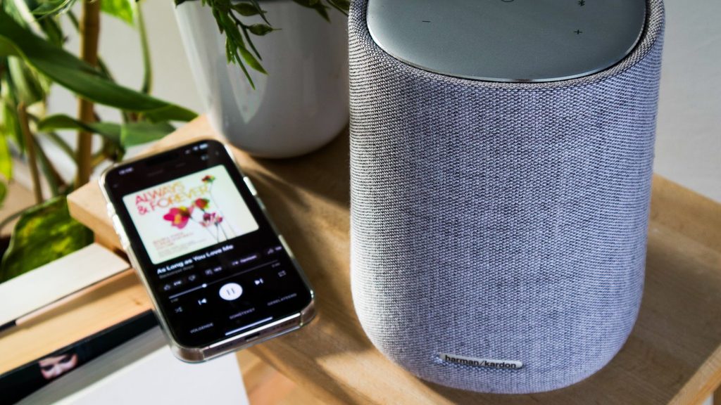 Caixa de som Bluetooth ao lado de um celular em ambiente interno