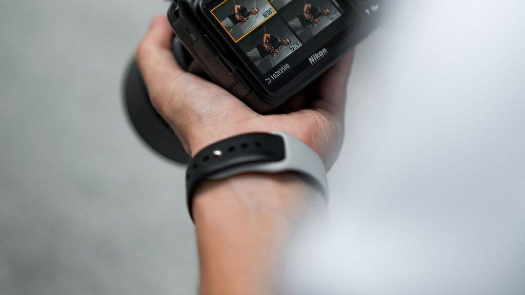 Mãos segurando uma câmera DSLR para fotografar retratos